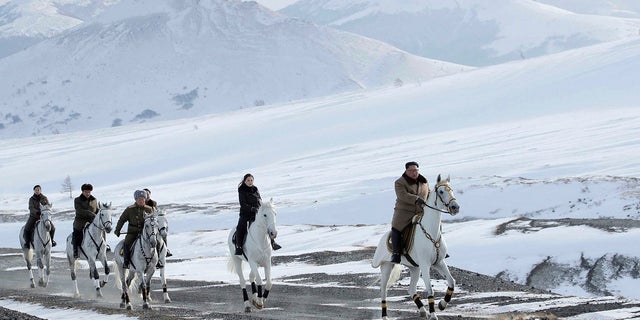 Kim Jong Un, right, and his wife Ri Sol Ju, second from right, riding on white horse during a visit to Mount Paektu, North Korea. (Korean Central News Agency/Korea News Service via AP)
