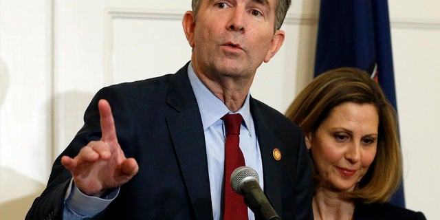In this Feb. 2, 2019 file photo Virginia Gov. Ralph Northam, left, gestures as his wife, Pam, listens during a press conference in the Governors Mansion at the Capitol in Richmond. A commission Northam tasked with researching racist laws from the state’s past recommended Thursday that dozens be repealed in order to purge the state’s books of discriminatory language. (AP Photo/Steve Helber, File)