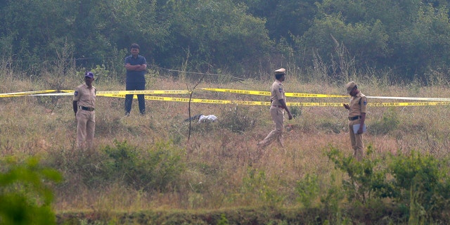 Indian policemen stand guard the area where rape accused were shot on the outskirts of Chattanpally in Shadnagar some 50 kilometers or 31 miles from Hyderabad, India, Friday, Dec. 6, 2019. An Indian police official says four men accused of raping and killing a woman in southern India have been fatally shot by police. (AP Photo/Mahesh Kumar A.)