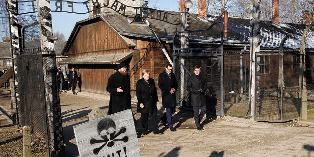 Museum director Piotr Cywinski, German Chancellor Angela Merkel, Polish Prime Minister Mateusz Morawiecki and deputy director Andrzej Kacorzyk, from left, visit the former Nazi death camp of Auschwitz-Birkenau in Oswiecim, Poland on Friday, Friday, Dec. 6, 2019. (AP Photo/Czarek Sokolowski)