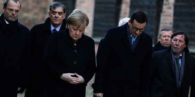 German Chancellor Angela Merkel, center left, and Polish Prime Minister Mateusz Morawiecki, center right, attend a wreath-laying ceremony at the death wall in the former Nazi death camp of Auschwitz-Birkenau in Oswiecim, Germany, Friday, Dec. 6, 2019. Merkel visits the former death camp in the occasion of the 10th anniversary of the founding of the Auschwitz Foundation.