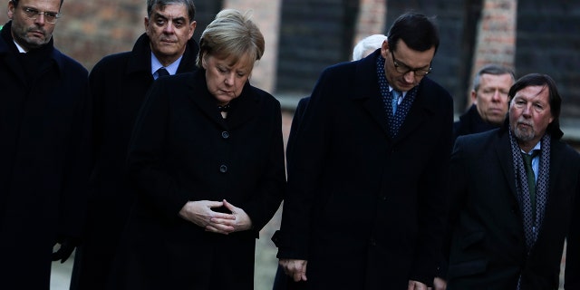 German Chancellor Angela Merkel, center left, and Polish Prime Minister Mateusz Morawiecki, center right, attend a wreath-laying ceremony at the death wall in the former Nazi death camp of Auschwitz-Birkenau in Oswiecim, Germany, Friday, Dec. 6, 2019. Merkel visits the former death camp in the occasion of the 10th anniversary of the founding of the Auschwitz Foundation.