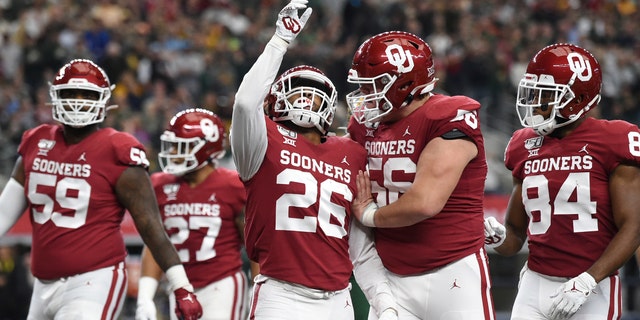 Oklahoma running back Kennedy Brooks (26) celebrates with offensive lineman Creed Humphrey (56) after rushing for a touchdown against Baylor during the first half of an NCAA college football game for the Big 12 Conference championship, Saturday, Dec. 7, 2019, in Arlington, Texas. (AP Photo/Jeffrey McWhorter)