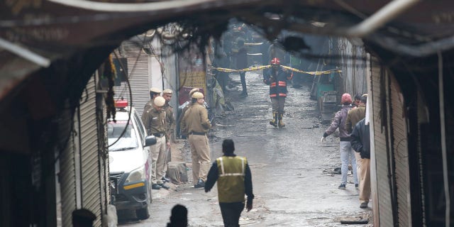 Police officers cordon off the site of a fire in a narrow lane in New Delhi, India, Sunday, Dec. 8, 2019. A doctor at a government-run hospital says dozens have died in a major fire in central New Delhi. (Associated Press)