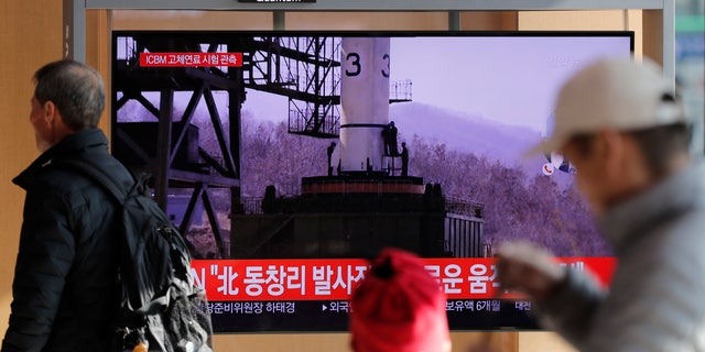 People watch a TV news program reporting North Korea's announcement with file image at the Seoul Railway Station in Seoul, South Korea, Sunday, Dec. 8, 2019. North Korea said Sunday it carried out a “very important test” at its long-range rocket launch site that it reportedly rebuilt after having partially dismantled it after entering denuclearization talks with the United States last year. The part of letters read "North. Tongchang-ri." (AP Photo/Lee Jin-man)