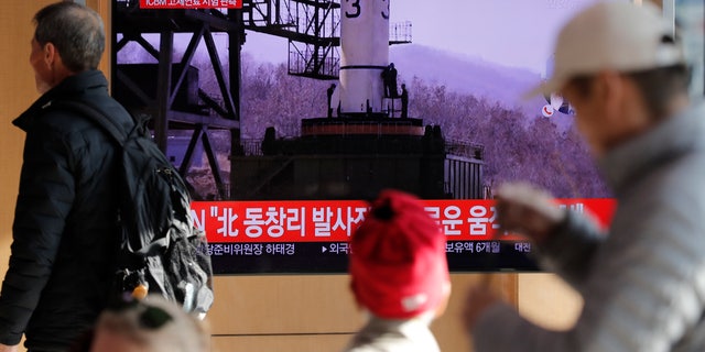 People watch a TV news program reporting North Korea's announcement with file image at the Seoul Railway Station in Seoul, South Korea, Sunday, Dec. 8, 2019. North Korea said Sunday it carried out a “very important test” at its long-range rocket launch site that it reportedly rebuilt after having partially dismantled it after entering denuclearization talks with the United States last year. The part of letters read "North. Tongchang-ri." (AP Photo/Lee Jin-man)