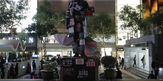 A statue on Statue Square is plastered with protest posters during a rally in Hong Kong on Sunday, Dec. 8, 2019. Hundreds of thousands of demonstrators crammed into Hong Kong's streets on Sunday, their chants echoing off high-rises, in a mass show of support for a protest movement that shows no signs of flagging as it enters a seventh month. (AP Photo/Kin Cheung)