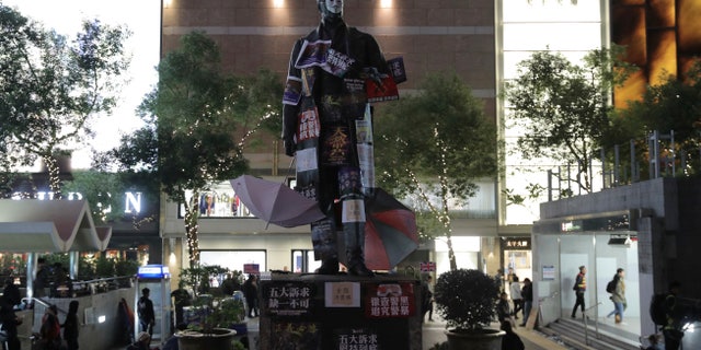 A statue on Statue Square is plastered with protest posters during a rally in Hong Kong on Sunday, Dec. 8, 2019. Hundreds of thousands of demonstrators crammed into Hong Kong's streets on Sunday, their chants echoing off high-rises, in a mass show of support for a protest movement that shows no signs of flagging as it enters a seventh month. (AP Photo/Kin Cheung)