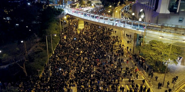 Pro-democracy protesters march into the night in Hong Kong, Sunday, Dec. 8, 2019. Hundreds of thousands thronged Hong Kong streets Sunday, in a mass show of support for a protest movement that shows no signs of flagging as it enters a seventh month. (AP Photo/Dake Kang)
