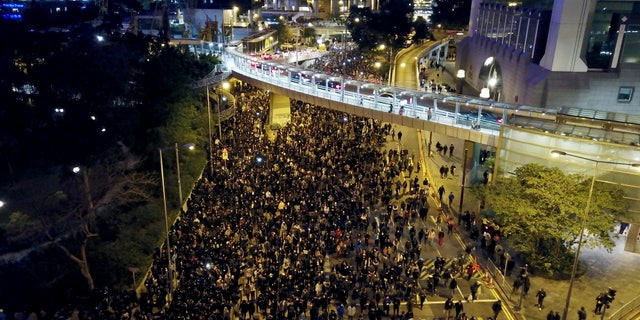 Pro-democracy protesters march into the night in Hong Kong, Sunday, Dec. 8, 2019. Hundreds of thousands thronged Hong Kong streets Sunday, in a mass show of support for a protest movement that shows no signs of flagging as it enters a seventh month. (AP Photo/Dake Kang)