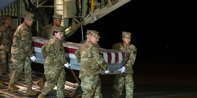 An Air Force carry team moves the transfer case containing the remains of Navy Seaman Apprentice Cameron Scott Walters, of Richmond Hill, Ga., Sunday, Dec. 8, 2019, at Dover Air Force Base, Del. A Saudi gunman killed three people including Walters in a shooting at Naval Air Station Pensacola in Florida.