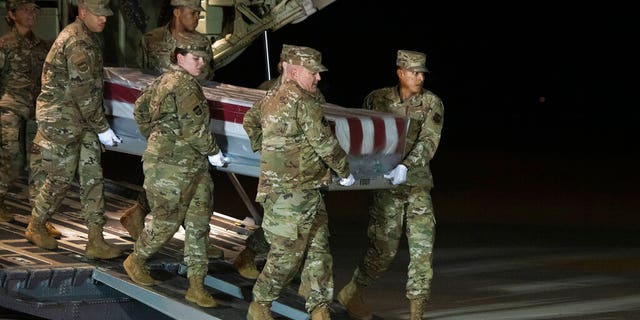 An Air Force carry team moves the transfer case containing the remains of Navy Seaman Apprentice Cameron Scott Walters, of Richmond Hill, Ga., Sunday, Dec. 8, 2019, at Dover Air Force Base, Del. A Saudi gunman killed three people including Walters in a shooting at Naval Air Station Pensacola in Florida.