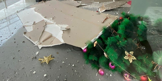 A toppled Christmas tree and other debris are seen inside a building after a strong earthquake shook Digos, Davao del Sur province, southern Philippines on Sunday Dec. 15, 2019. (Philippine Red Cross via AP)