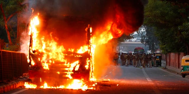 A passenger bus up in flames during a protest against Citizenship Amendment Act in New Delhi, India, on Sunday. (AP Photo)