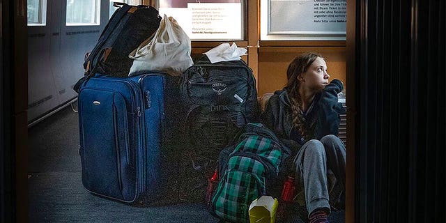 In this image taken from Twitter feed of Climate activist Greta Thunberg, showing Thunberg sitting on the floor of a train surrounded by bags Saturday Dec. 14, 2019, with the comment “traveling on overcrowded trains through Germany. And I’m finally on my way home!” (Twitter @GretaThunberg via AP)