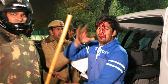 Policemen detaining an injured student outside Jamia Millia Islamia during a protest against Citizenship Amendment Act on Sunday. (AP Photo/Saaliq Sheikh)