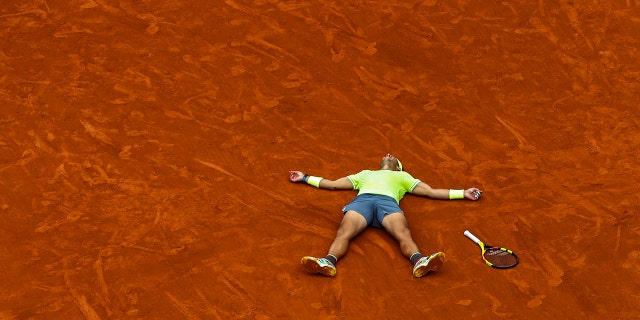 Spain's Rafael Nadal celebrates his record 12th French Open tennis tournament title after winning his men's final match against Austria's Dominic Thiem in four sets, 6-3, 5-7, 6-1, 6-1, at the Roland Garros stadium in Paris, June 9, 2019. (AP Photo/Pavel Golovkin)