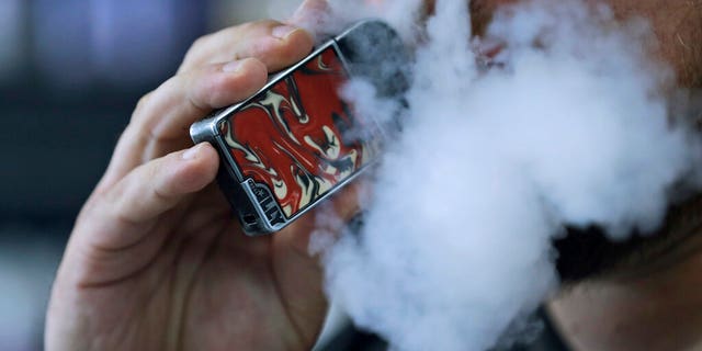 FILE: A man using an electronic cigarette exhales in Mayfield Heights, Ohio.