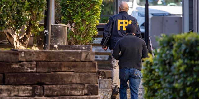 In this Wednesday, Dec. 18, 2019 photo, FBI agents canvas the neighborhood searching for information on Heidi Broussard, a missing Austin, Texas, woman and her infant daughter in South Austin, Texas. Authorities recovered a woman's body and found a child safe in a home on the outskirts of Houston. (Ricardo B. Brazziell/Austin American-Statesman via AP)