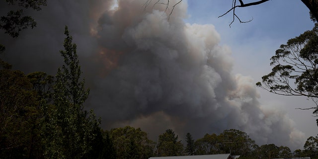 A home stands as smoke from the Grose Valley fire rises in the distance in Bilpin, west of Sydney, Saturday, Dec. 21, 2019. Australia’s most populous state has been paralyzed by “catastrophic” fire conditions Saturday amid soaring temperatures as wildfires also ravaged the country’s southeast. (AAP Image/Dan Himbrechts)