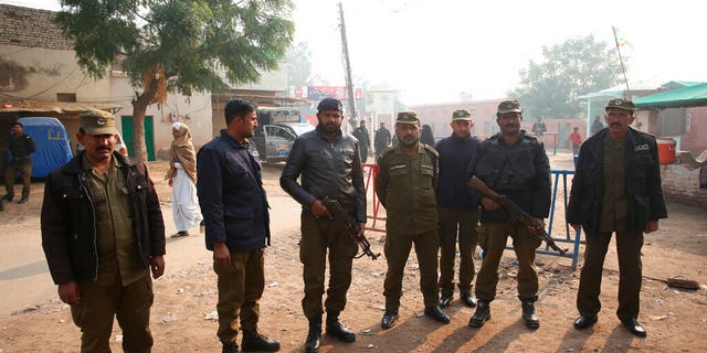 Pakistani police officers stand guard outside Multan jail after a court's decision for a professor facing blasphemy case, in Multan, Pakistan.
