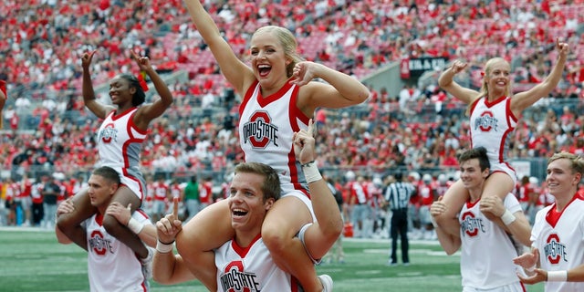 In this Aug. 31 file photo Ohio State cheerleaders yell to fans during an NCAA football game against Florida Atlantic in Columbus, Ohio. A New York-based sports network has turned to the federal courts in its trademark dispute with Ohio State University over the use of the letter “O.” (AP Photo/Paul Vernon, File)