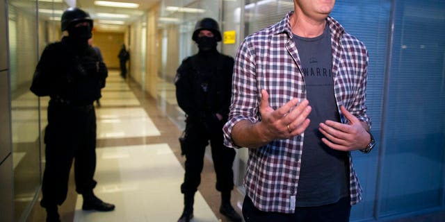 Russian opposition leader Alexei Navalny speaking to the media as police stood guard at the Foundation for Fighting Corruption office in Moscow.