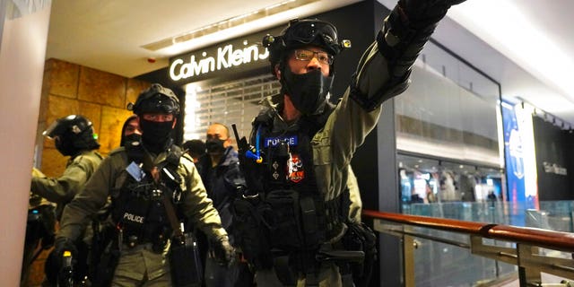 Riot police gesture as they gather at a shopping mall during a demonstration in Hong Kong, Thursday, Dec. 26, 2019. (AP Photo/Vincent Yu)