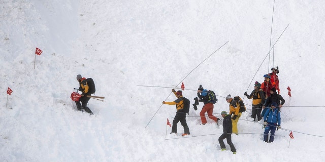 Rescue forces search for missing people after an avalanche swept down a ski piste in the central town of Andermatt, canton Uri, Switzerland, Thursday, Dec. 26, 2019. The avalanche occurred mid-morning Thursday while many holiday skiers enjoyed mountain sunshine the day after Christmas.