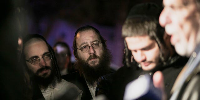 Orthodox Jewish people listen to N.Y. state Assemblyman Dov Hikind speak in Monsey, N.Y., Sunday, Dec. 29, 2019, following a stabbing late Saturday during a Hanukkah celebration. A man attacked the celebration at a rabbi's home north of New York City late Saturday, stabbing and wounding several people before fleeing in a vehicle, police said. (Associated Press)