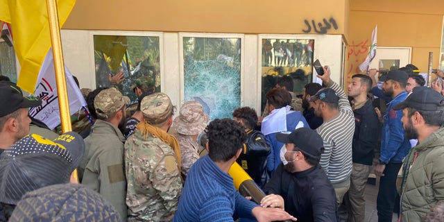 Protesters smashing a window inside the U.S. embassy compound Tuesday. (AP Photo/Khalid Mohammed)