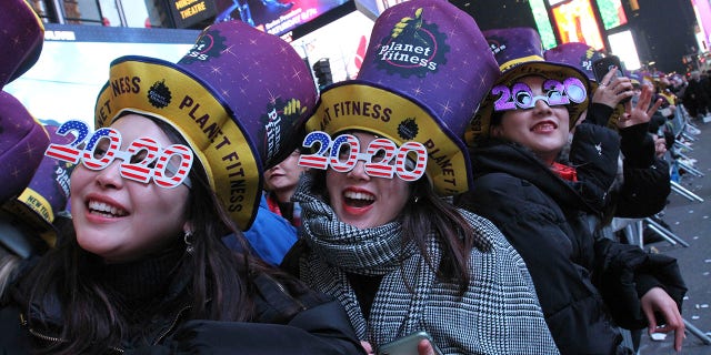 Revelers, including Natsumi Ishikawa, left, and Minori Kondo, second from left, both from Nagoya, Japan, take part in the New Year's Eve festivities in New York's Times Square, Tuesday, Dec. 31, 2019. (Associated Press)