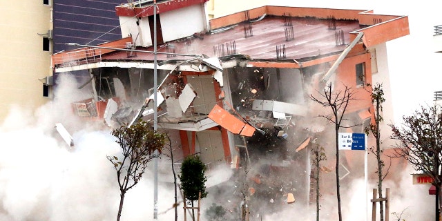 The Albanian army uses a remote-controlled explosion to demolish a building in the western port city of Durres, Albania, Tuesday, Dec. 3, 2019.