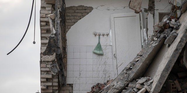 In this Wednesday, Nov. 27, 2019, a plastic bag with washing powder hangs on a wall of a collapsed building in Thumane, western Albania following a deadly earthquake.