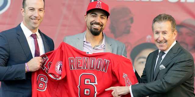 Los Angeles Angels team owner Arte Moreno, right, with general manager Billy Eppler, left, introducing the newest Angel, Anthony Rendon, center, with a jersey during a news conference in Anaheim, Calif., on Saturday. Rendon and the Los Angeles Angels agreed to a $245 million, seven-year contract earlier in the week. (AP Photo/Alex Gallardo)