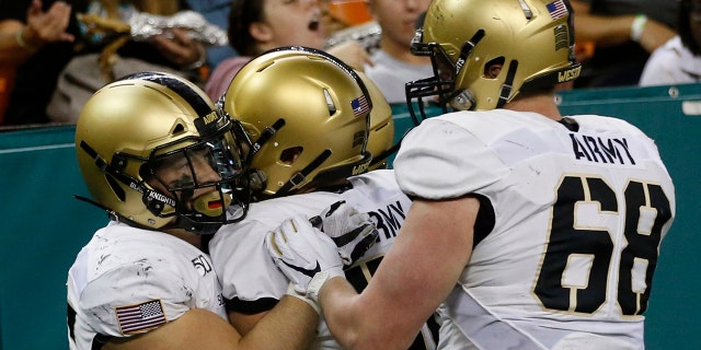 Army running back Connor Slomka (25) celebrates with teammates after making a touchdown against Hawaii during the second half of an NCAA college football game Saturday, Nov. 30, 2019 in Honolulu. (AP Photo/Marco Garcia)