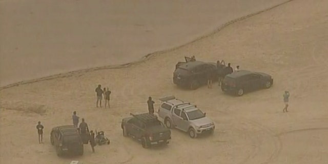 In this image made from video, people evacuate to a lake to escape wildfires Tuesday, Dec. 31, 2019, in Ulladulla, New South Wales, Australia.