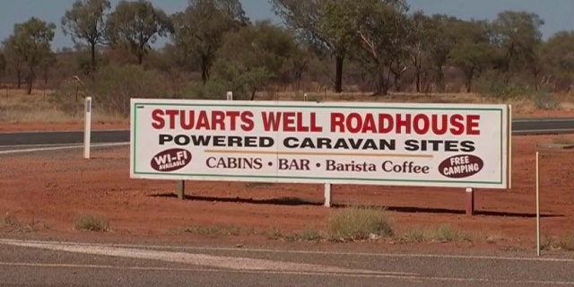 In this image made from video, an advertisement for the campsite line the roadside Tamra McBeath-Riley was found Sunday after being stranded in the Alice Springs area in the central Australian Outback.