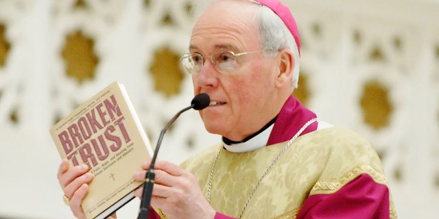 Bishop Richard Malone holds up a copy of the book "Broken Trust" during his homily Thursday, May 29, 2008, at a mass of prayer and penance for harm done to survivors and faithful by past incidents of clergy sexual abuse.