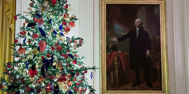 A decorated tree stands next to the portrait of President George Washington in the East Room during the 2019 Christmas preview at the White House, Monday, Dec. 2, 2019, in Washington. (AP Photo/Alex Brandon)