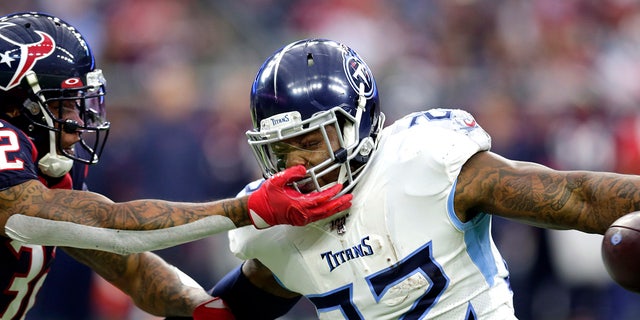 Houston Texans cornerback Lonnie Johnson (32) reaches to tackle Tennessee Titans running back Derrick Henry (22) during the first half of an NFL football game Sunday, Dec. 29, 2019, in Houston. (AP Photo/Michael Wyke)