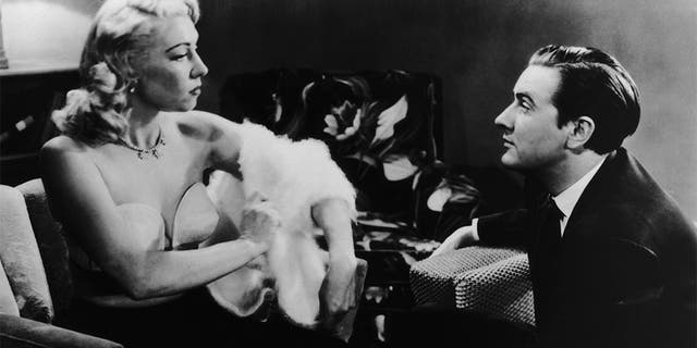 Edward D. Wood Jr. (1924 - 1978) watches actress Dolores Fuller remove her white angora sweater in a still from the film