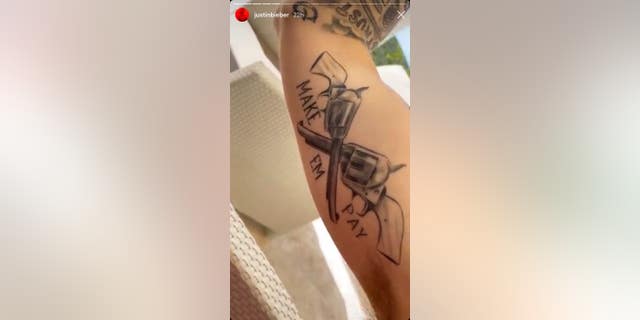 Bieber's bicep tattoo, which features two revolvers and the words 