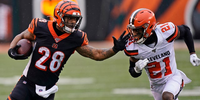Cincinnati Bengals running back Joe Mixon (28) rushes against Cleveland Browns cornerback Denzel Ward (21) during the first half of an NFL football game, Sunday, Dec. 29, 2019, in Cincinnati. (AP Photo/Bryan Woolston)