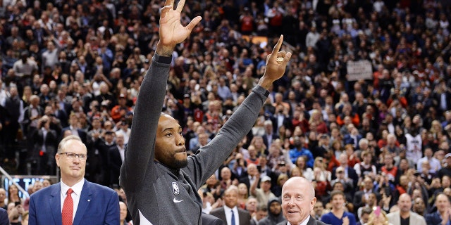 Former Toronto Raptors and now Los Angeles Clippers forward Kawhi Leonard salutes the crowd as he receives his 2019 NBA championship ring prior to an NBA basketball game, Wednesday, Dec. 11, 2019, in Toronto. (Nathan Denette/The Canadian Press via AP)