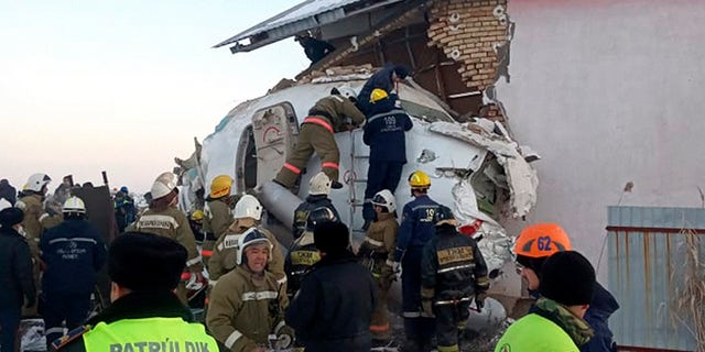 In this photo provided by the Emergency Situations Ministry of the Republic of Kazakhstan, police and rescuers work on the side of a plane crashed near Almaty International Airport, outside Almaty, Kazakhstan, Friday, Dec. 27, 2019. Almaty International Airport said a Bek Air plane crashed Friday in Kazakhstan shortly after takeoff causing numerous deaths.