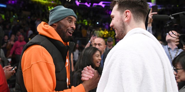Former Los Angeles Laker Kobe Bryant, left, greets Dallas Mavericks guard Luka Doncic after an NBA basketball game Sunday, Dec. 29, 2019, in Los Angeles. The Lakers won 108-95. (AP Photo/Michael Owen Baker)