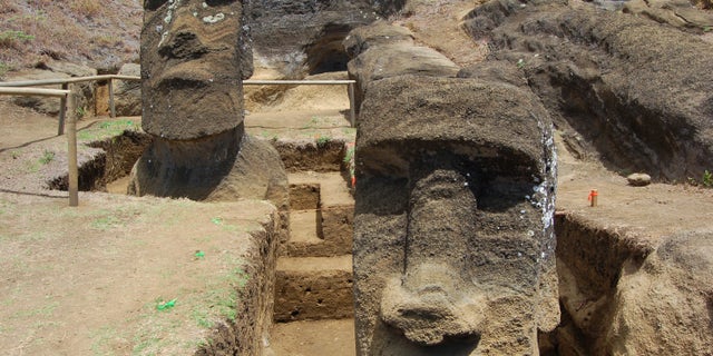 View from downslope of two Moai during excavations by Jo Anne Van Tilburg and her team at Rano Raraku quarry, Rapa Nui.