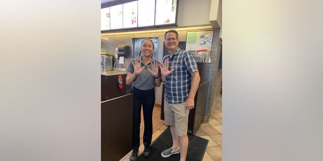 One of Mendenhall's self-imposed rules stipulated that he needed to take a photo on each visit. As seen above, Mendenhall and an employee celebrate his 15th visit in as many business days.