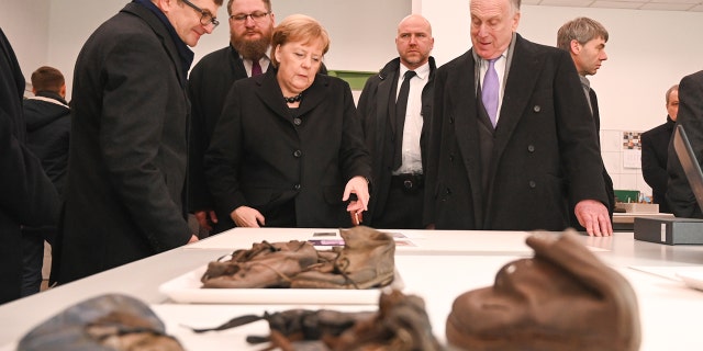 On December 6, 2019, in the Auschwitz-Birkenau State Museum’s Conservation Laboratories, funded by World Jewish Congress President Ronald S. Lauder, Lauder shows German Chancellor Angela Merkel the shoes of children who were imprisoned at the site of the former concentration and extermination camp.